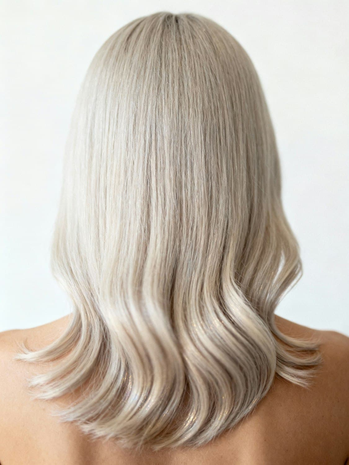 Long platinum blonde hair in soft waves, seen from behind